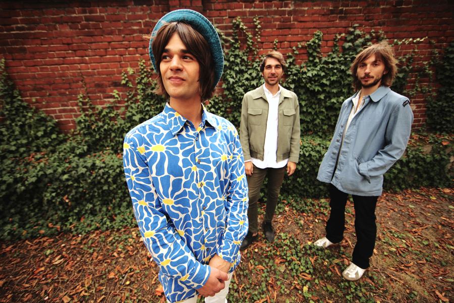 The band by a red brick wall with ivy