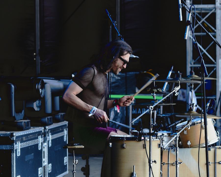 Drummer from the side, dark stage
