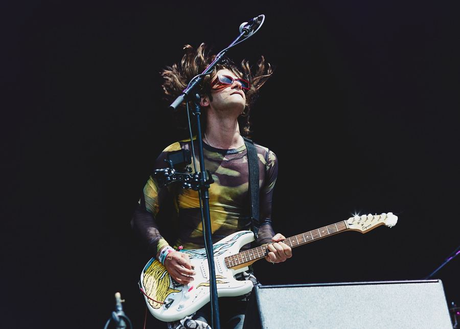 Guitarist mid-headbang in red sunglasses